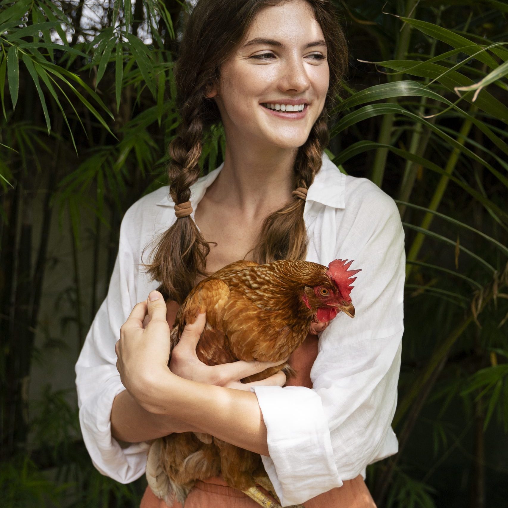 front-view-smiley-woman-holding-hen
